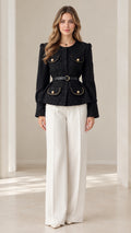 Front full-length view of model wearing black belted tweed peplum jacket with white trousers