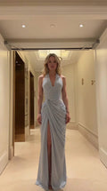 Front view of model wearing light blue halter ruched maxi dress with high slit