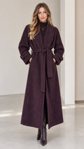 Front view of woman wearing deep plum herringbone maxi wrap coat with belt