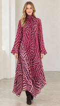 Front view of model wearing magenta abstract print high neck asymmetrical maxi dress