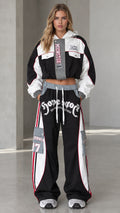 Front view of model wearing black cropped hooded jacket and wide-leg cargo track pants set