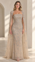 Front view of model wearing champagne beaded strapless evening gown with sheer cape