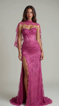 Front view of model wearing magenta lace corset evening gown with sheer capelet and high slit