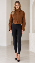 Front full view of woman wearing Caramel Brown cropped high-neck jacket with scarf tie and black leggings