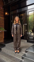 Front full view of woman wearing dark brown faux leather jacket and trousers set