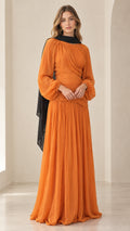 Full-length front view of woman wearing orange pleated chiffon maxi dress with black neck scarf