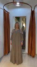 Front view of woman wearing mocha pleated maxi dress with crystal-embroidered yoke