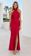 Front full-length view of model wearing a red halter neck satin maxi dress with a side slit