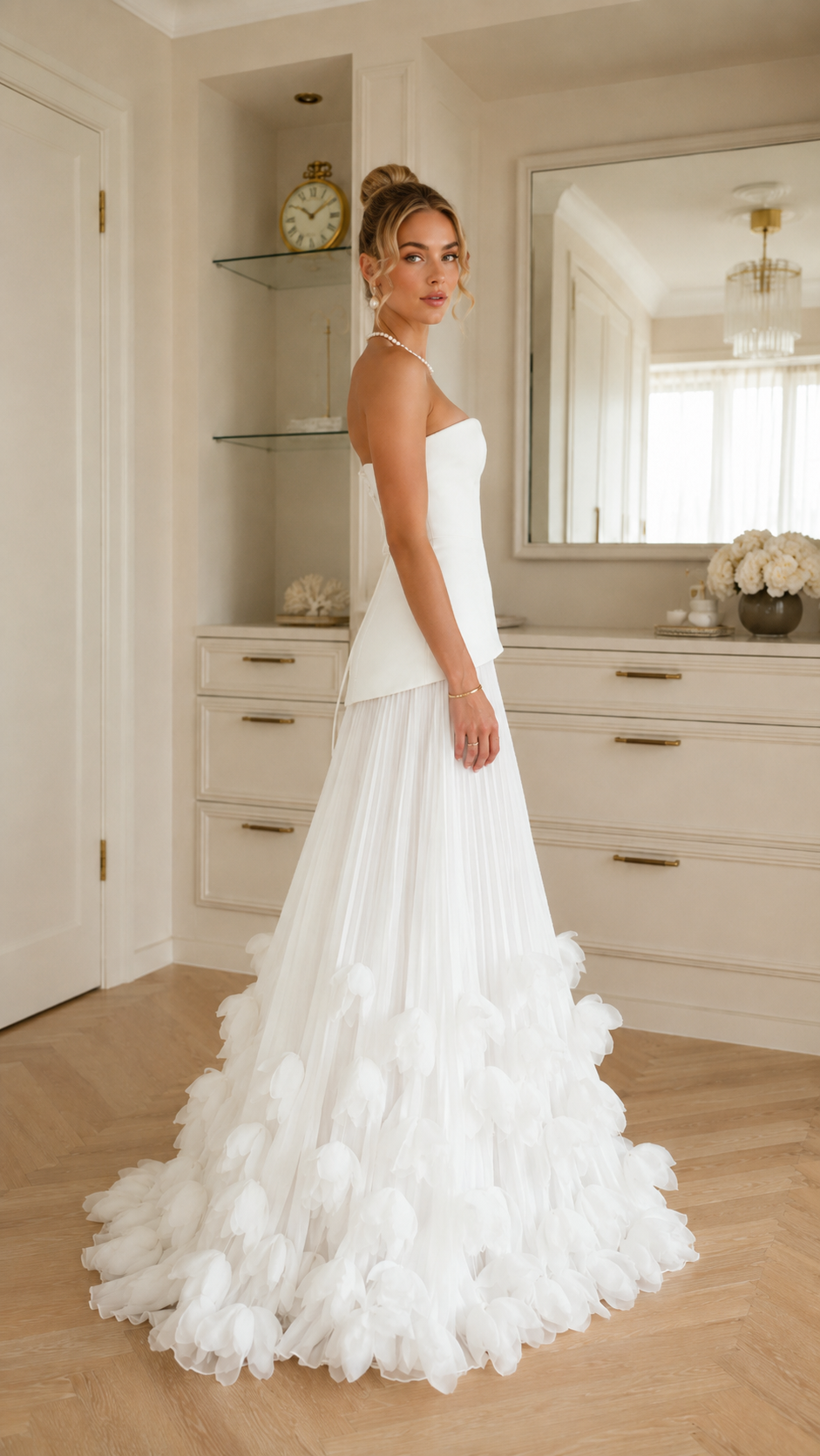 Side view of ivory strapless formal dress with pleated lower skirt and voluminous hem
